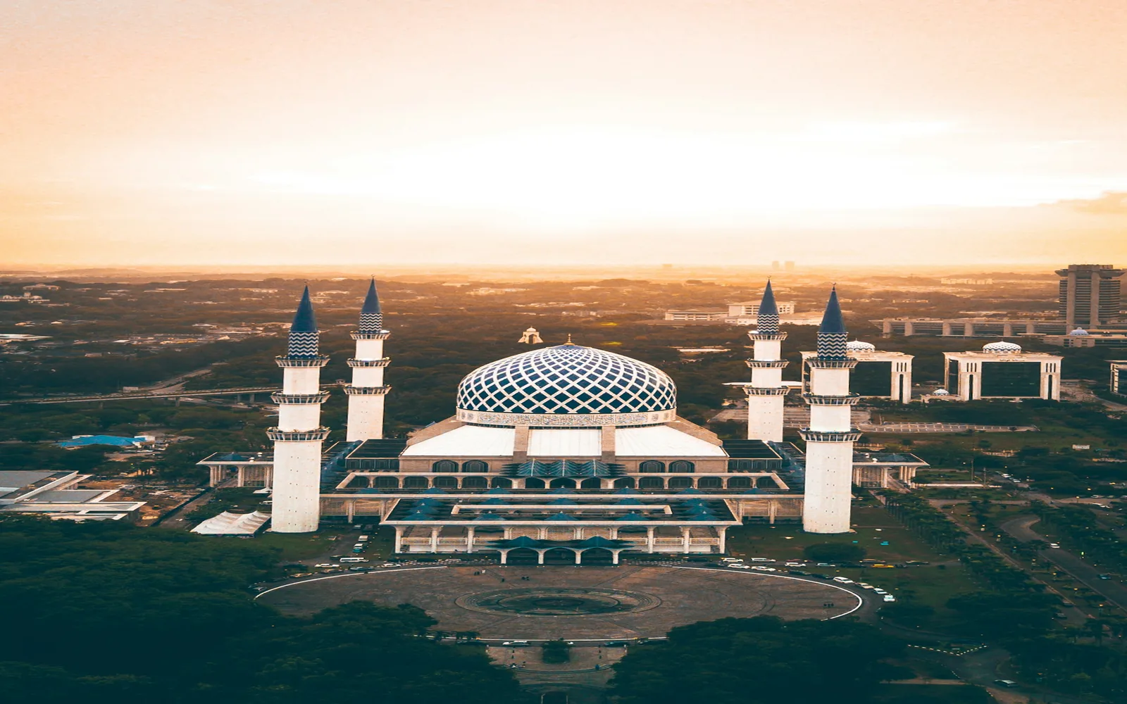 Akşam ışığında bir caminin minareleri ve kubbesi